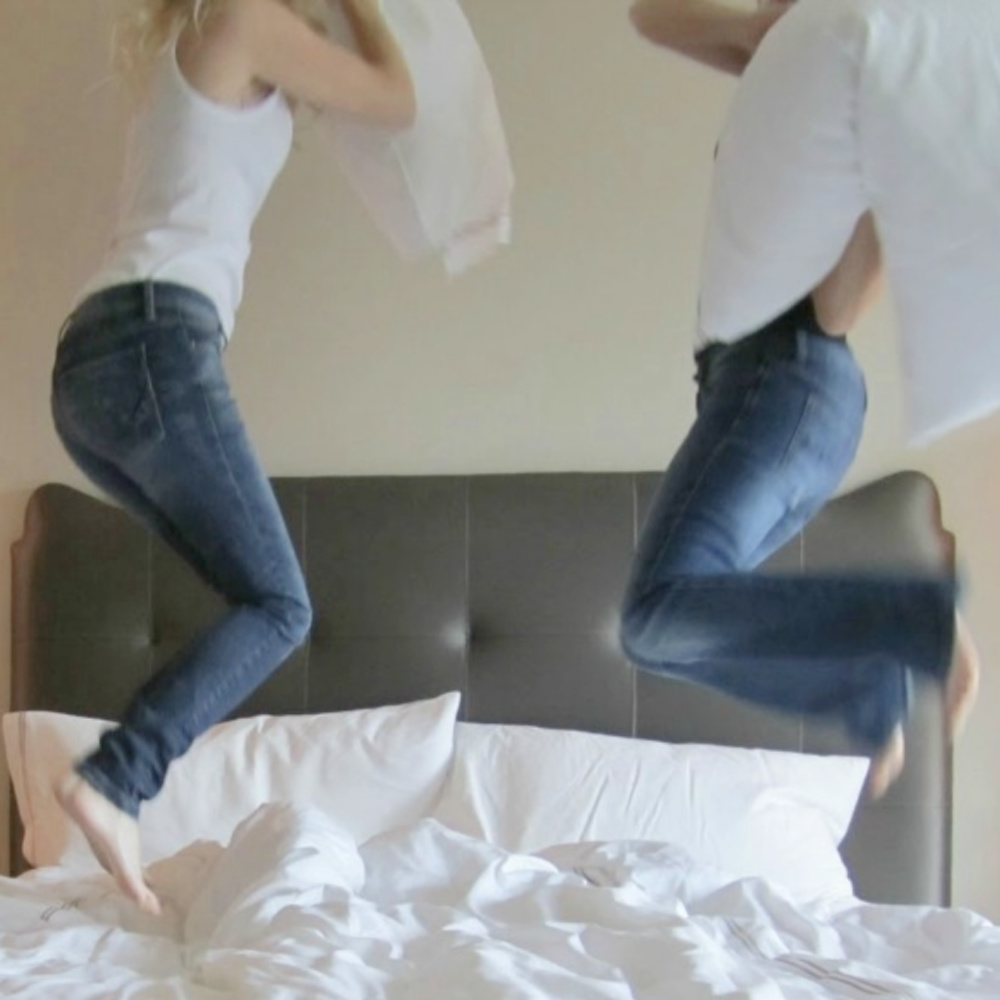 Yummy white sheets on bed and friends in denim jumping for pillow fight - Hello Lovely Studio. #whitesheets