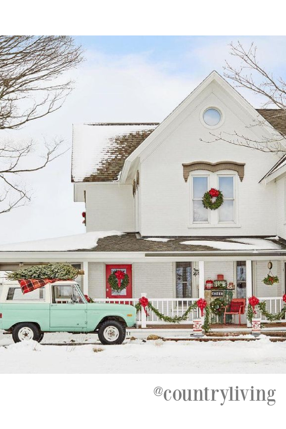 Charming white farmhouse decorated for Christmas - Country Living. #countrychristmas #farmhousechristmas #outdoorchristmasdecor