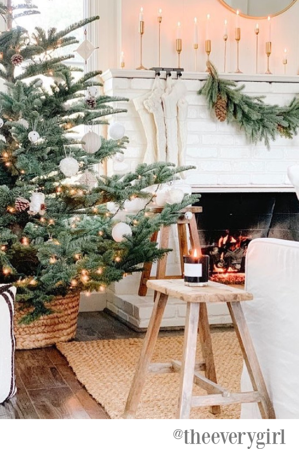 Farmhouse Christmas decor in a living room with white brick fireplace - The Every Girl. #whitechristmas #farmhousechristmas #christmastrees