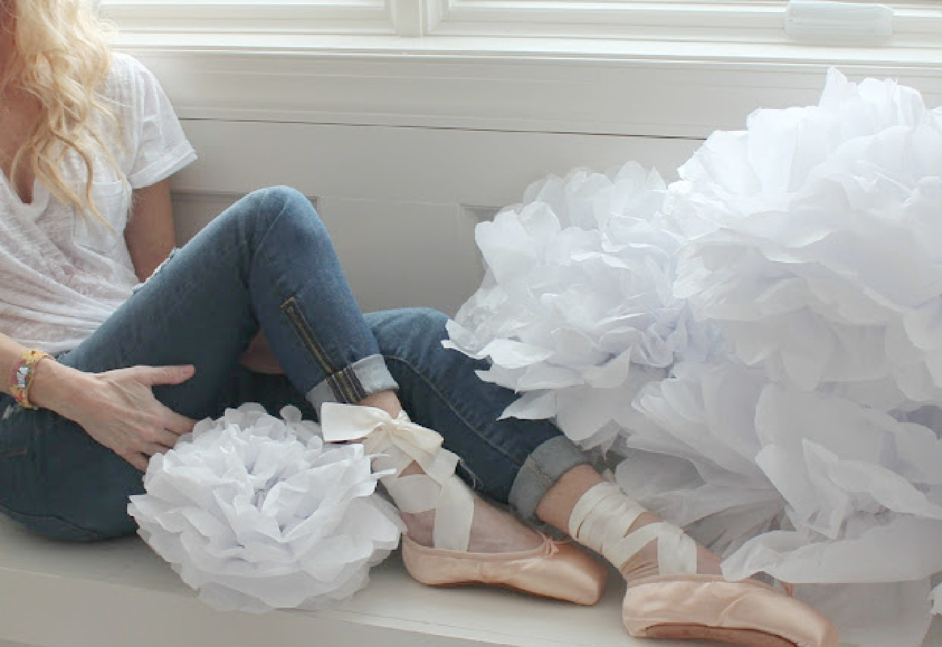 Michele of Hello Lovely with pointe shoes and tissue flowers on a window seat.