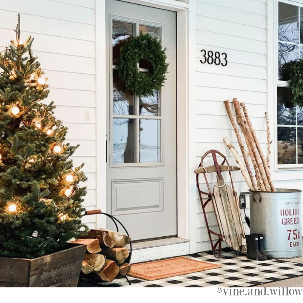 Beautiful Christmas decor on a country porch with tree and sled - Vine and Willow. #christmasdecor #farmhousechristmas