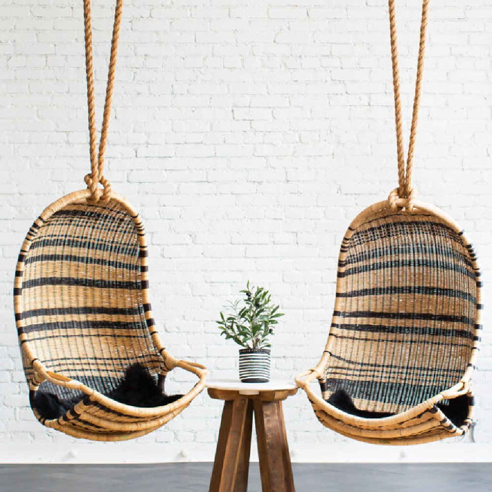 Two rattan hanging chair swings with black stripes and white brick wall at Grayson headquarters in LA - design by AR Interiors (Anna Rosemann). #hangingchair #modernrustic #chairswings