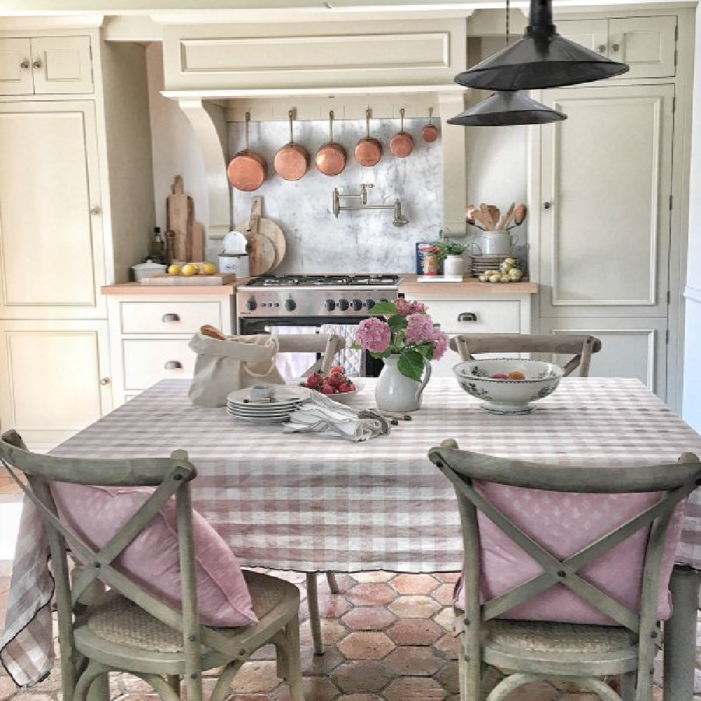 Rustic French farmhouse kitchen with beams, terracotta hex tile floor, putty cabinets, and traditional charm - Vivi et Margot. #frenchfarmhouse #kitchens