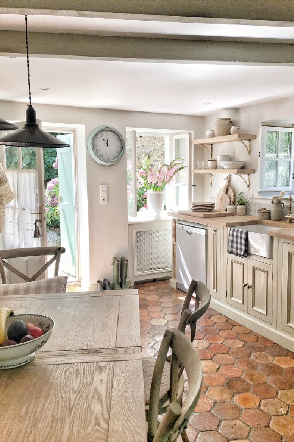 Rustic French farmhouse kitchen with beams, terracotta hex tile floor, putty cabinets, and traditional charm - Vivi et Margot. #frenchfarmhouse #kitchens