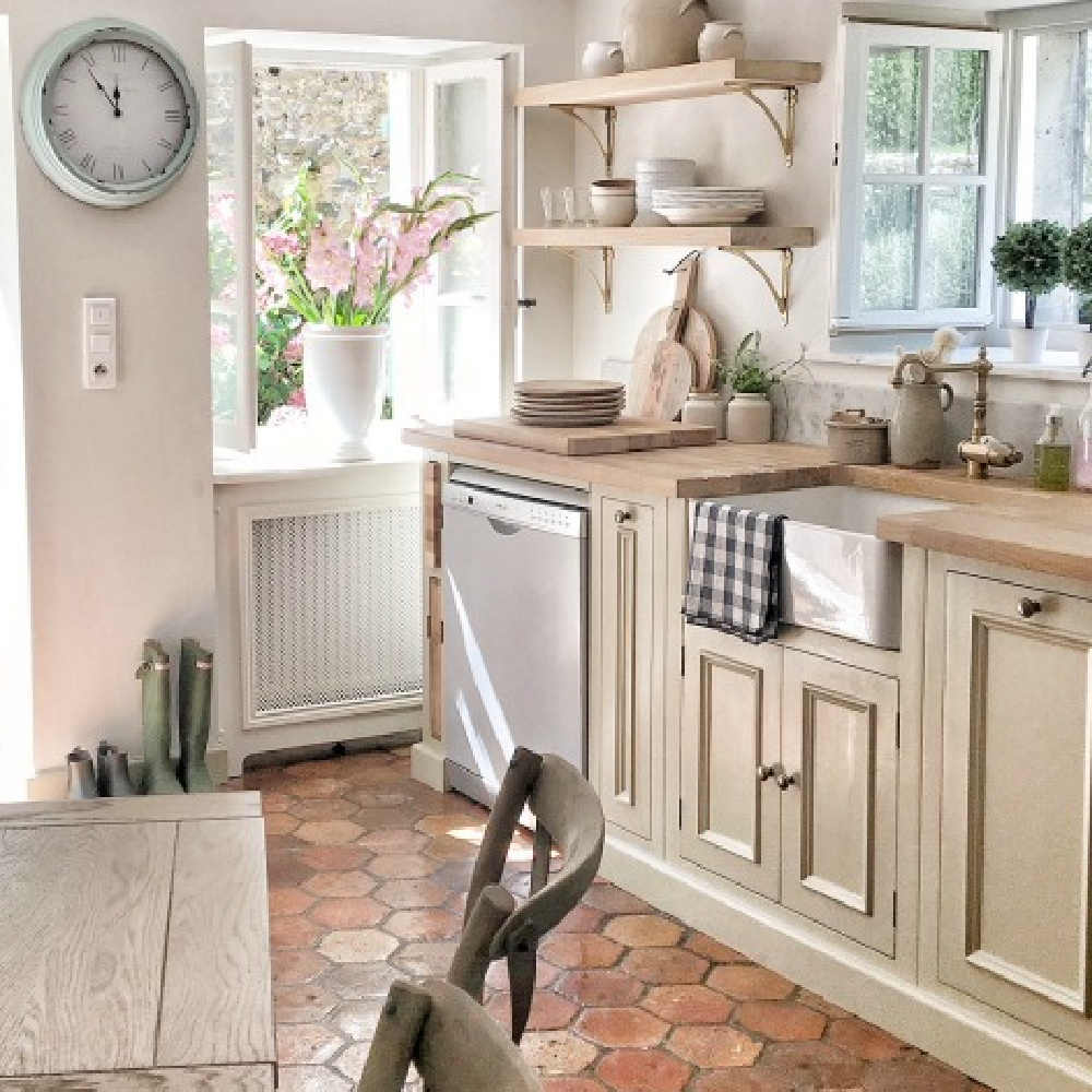 French farmhouse kitchen with beams, terracotta hex tile floor, warm gray cabinets, and traditional charm - Vivi et Margot. #frenchfarmhouse #greigekitchen