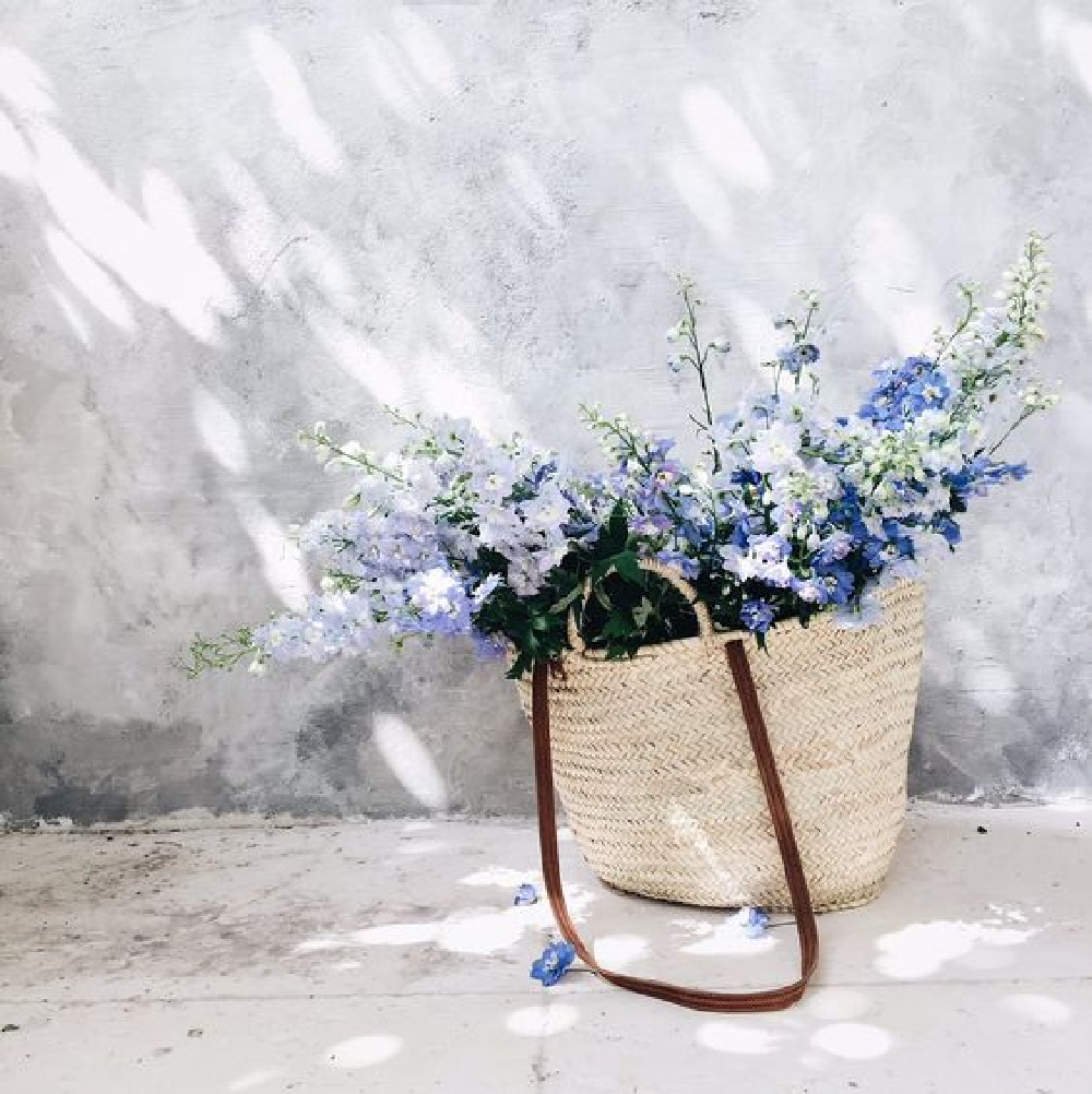 Beautiful French market basket filled with blue blooms - Vivi et Margot. #frenchcountrybasket #marketbasket