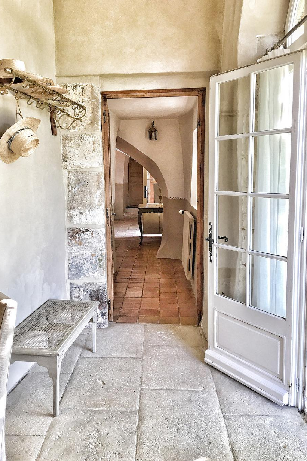 Rugged stone walls in a charming entry of a French country home - Vivi et Margot.