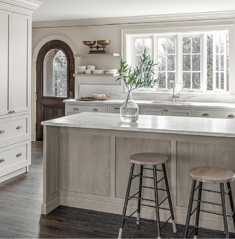 Minimal modern classic kitchen with subdued neutral palette, white trim, and arched door - Michael Del Piero. #nowallcabinets #kitchendesign