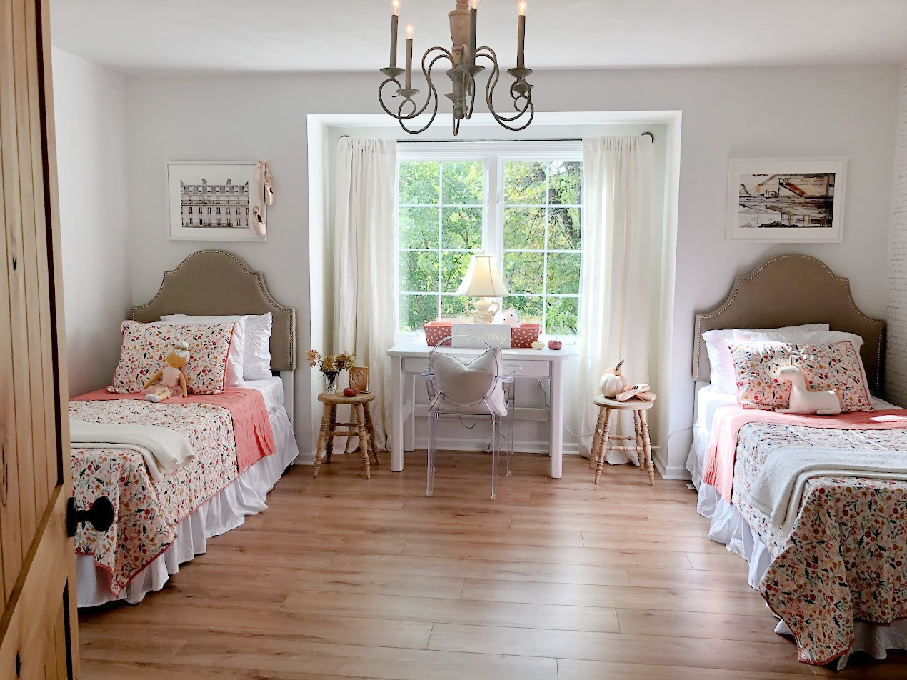 Upholstered linen headboards in a guest bedroom with pink floral quilts - Hello Lovely Studio