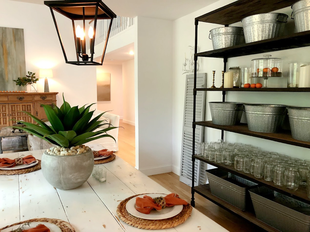 European country dining room with white farm table, rustic shelves, and lantern - Hello Lovely Studio.