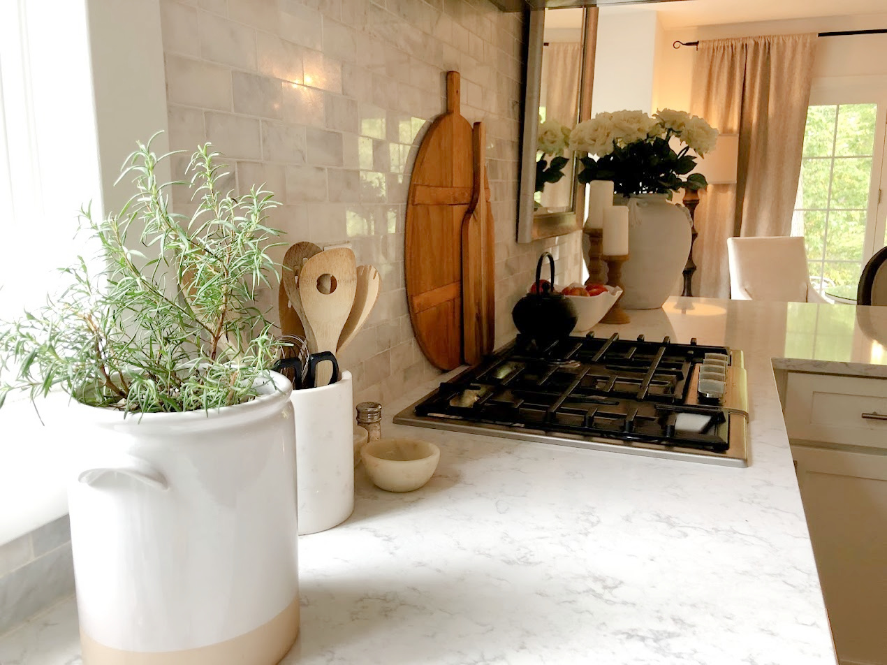 Serene white kitchen with Viatera Minuet white quartz counters, polished marble backsplash, and Bosch appliances - Hello Lovely Studio.