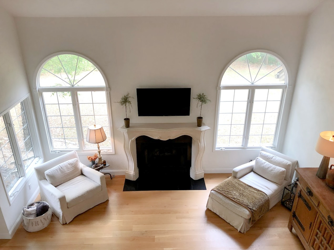 Hello Lovely's European country style living room with French inspired fireplace surround and white oak hardwoods.