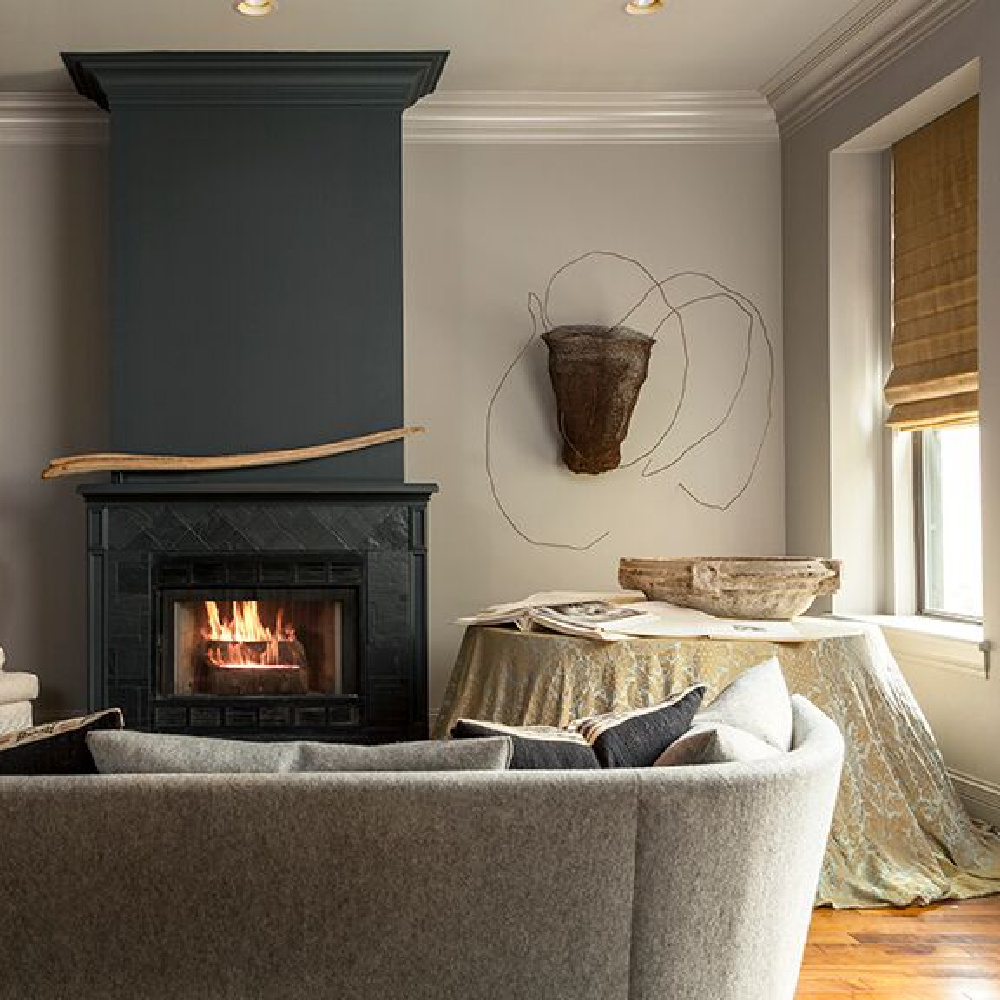 Black fireplace in a moody Chicago living room by Michael Del Piero.