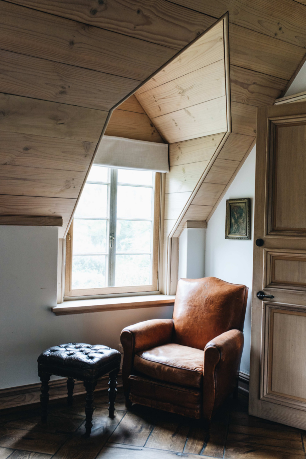 Vintage leather chair near dormer window in a cozy nook of bedroom at Wollumbi. From Melissa Penfold's book LIVING WELL BY DESIGN (Vendome, 2021).