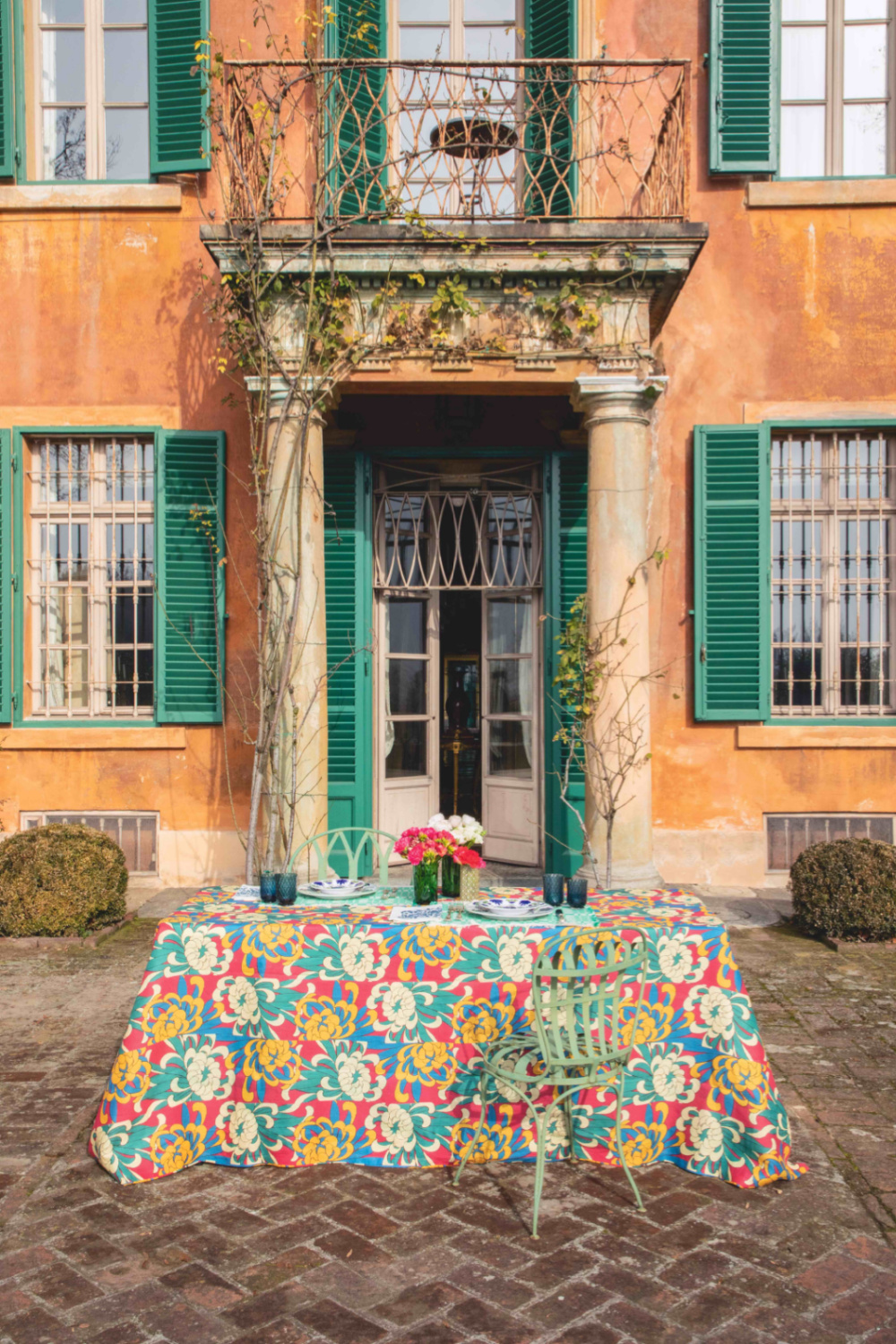 Vibrant yellow villa exterior with green shutters and Dahlia Tablecloth - Casa Cabana.