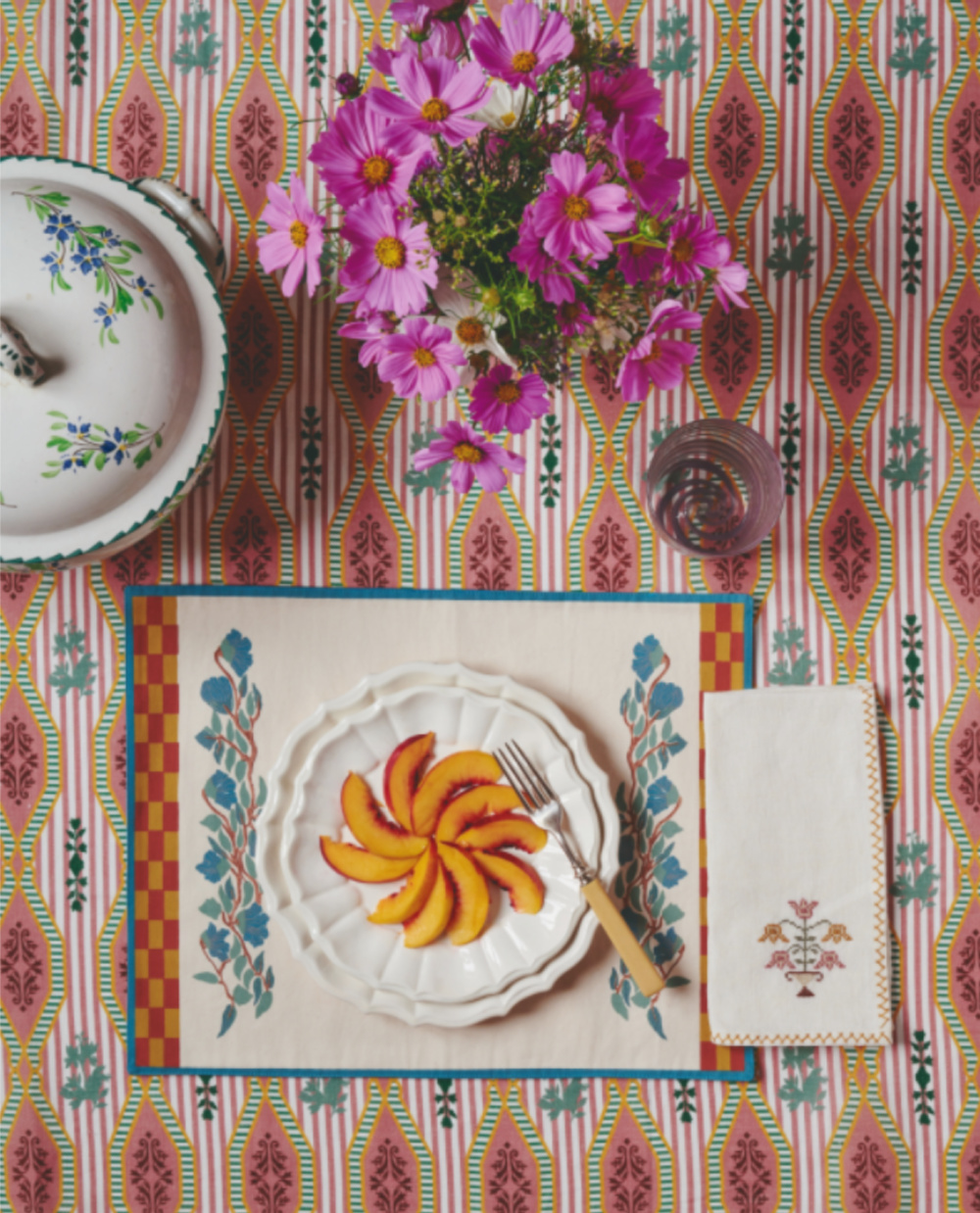 Vivid colorful Rosa Tableccloth (Casa Cabana) and beautiful tablescape with flowers and peaches on a plate - Martina Mondadori. #tablescapes #colorfultablecloth