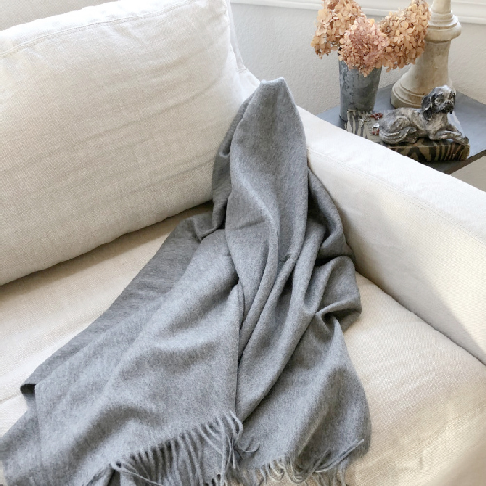 Grey cashmere fringe throw on a Belgian linen club chair in my living room - Hello Lovely Studio.