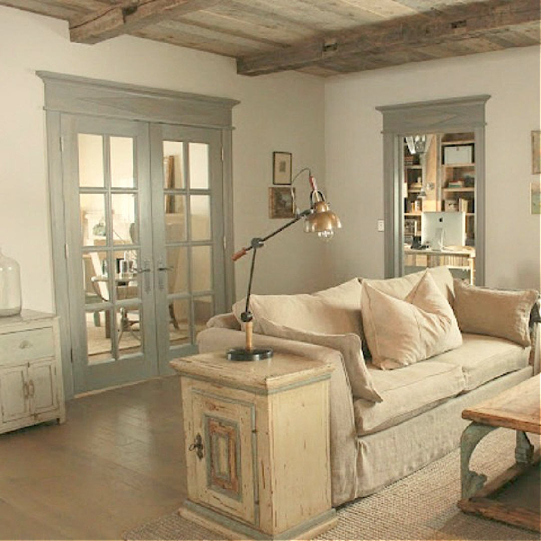 Rustic French farmhouse European country living room with linen sofa, blue-gray trim, and warm light neutrals in a cottage by Desiree of Beljar Home and Decor de Provence. #frenchcountry #frenchfarmhouse #livingrooms