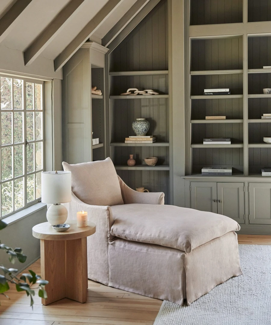 Miramar chaise in a lovely grey-green room with side table, orb lamp, and candle - Jenni Kayne.