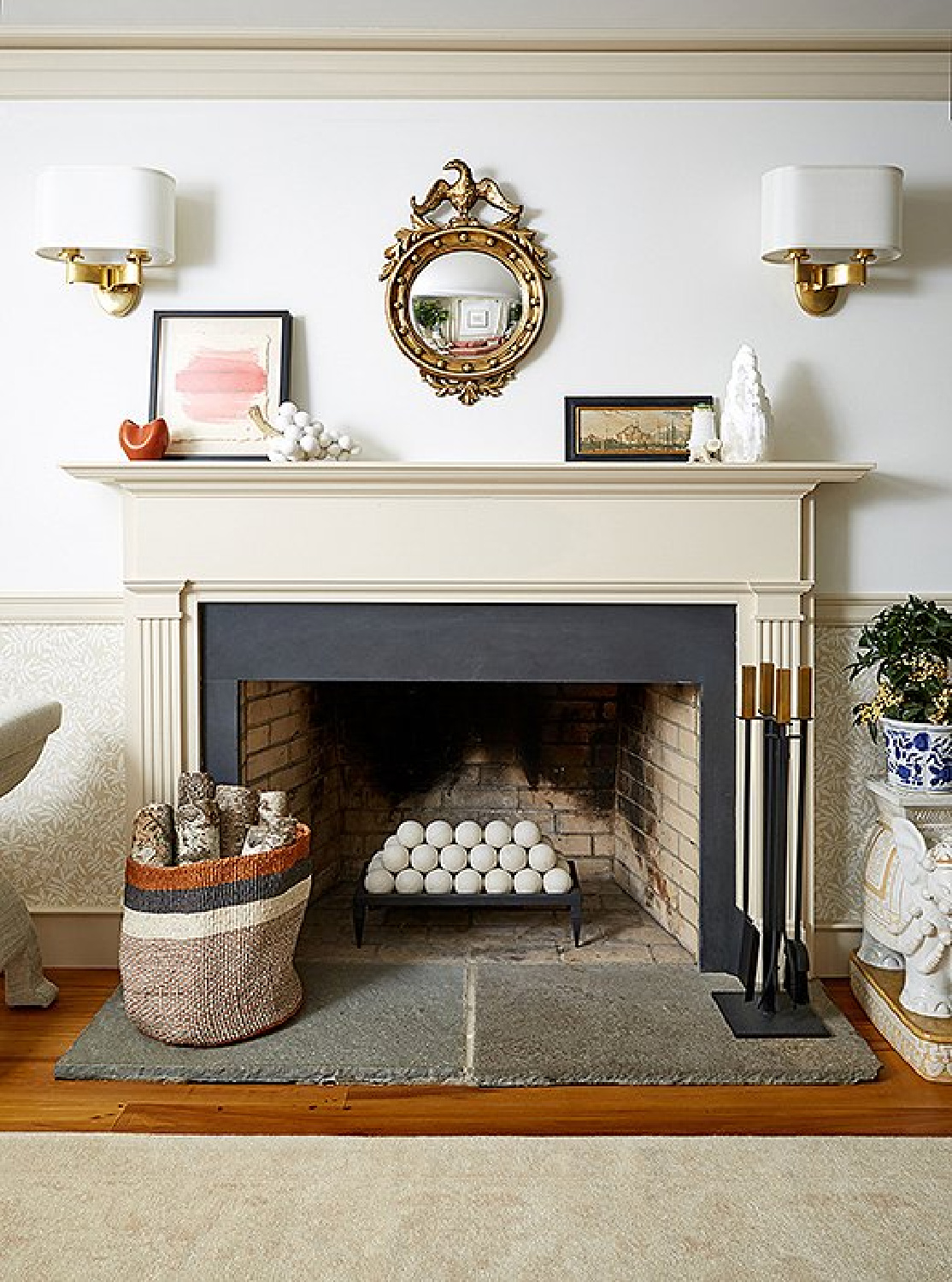 Detail of fireplace with fire spheres and classic interior design in a New England farmhouse - OKL.