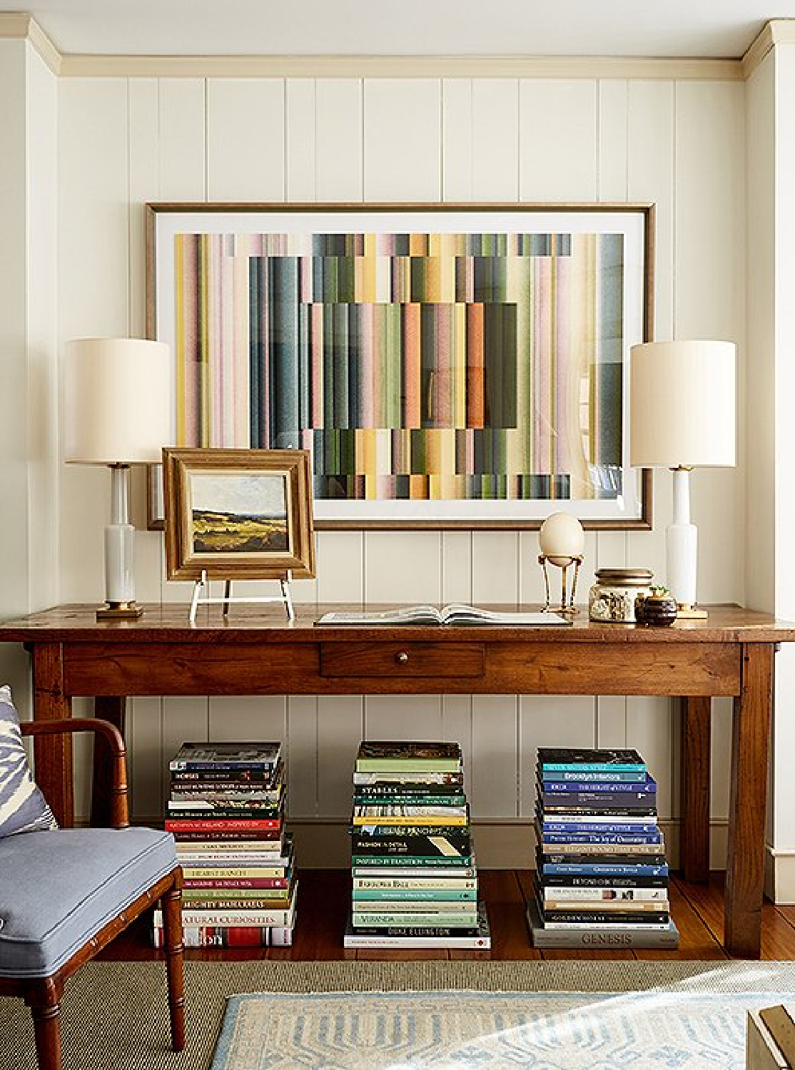 Family room with console table, stacks of colorful books, and modern art - OKL.