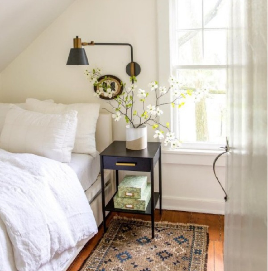 Simple country bedroom with white ilnen bedding and black wall sconce - And North. #bedroomdesign #countrybedroom #interiordesign #simpledecor #whitelinen