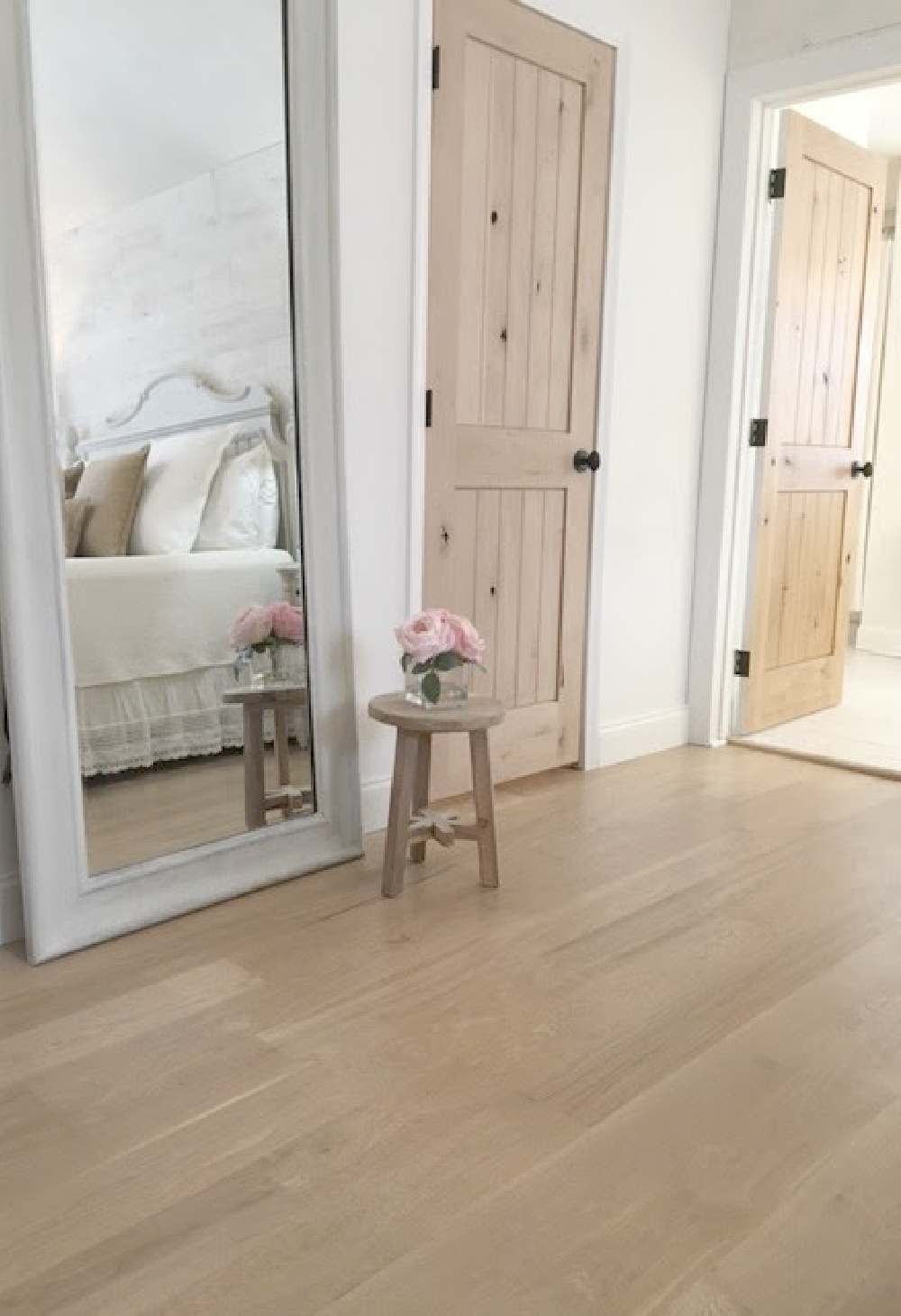 My master bedroom with white oak hardwood flooring and rustic alder doors - Hello Lovely Studio.