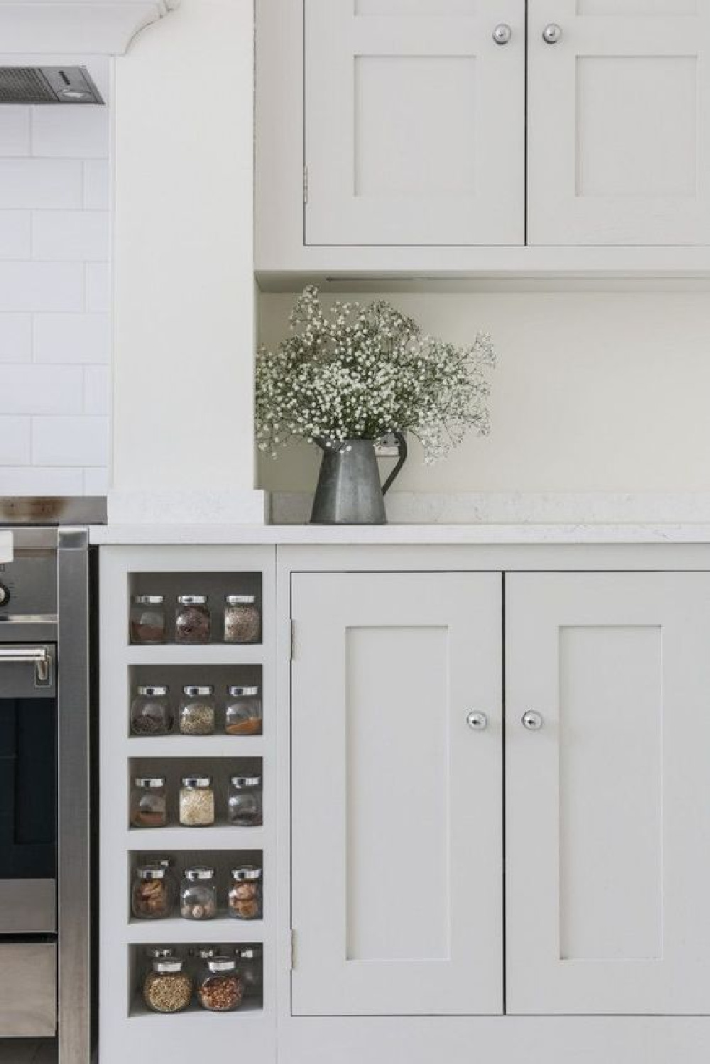 Sustainable Kitchens - Bright Open Plan Family Kitchen in London. Oak shaker style cabinetry painted in Farrow & Ball Ammonite with built in spice racks on both sides of the Smeg range cooker. The worktop is Bianco Fantasia.