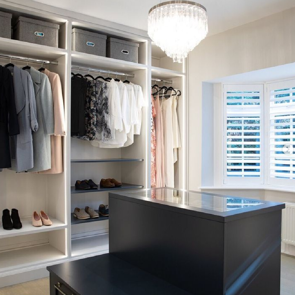 Beautiful custom closet with window, chandelier, island, and bespoke details - @johnlewisofhungerford. #customcloset #luxurycloset #dressingrooms