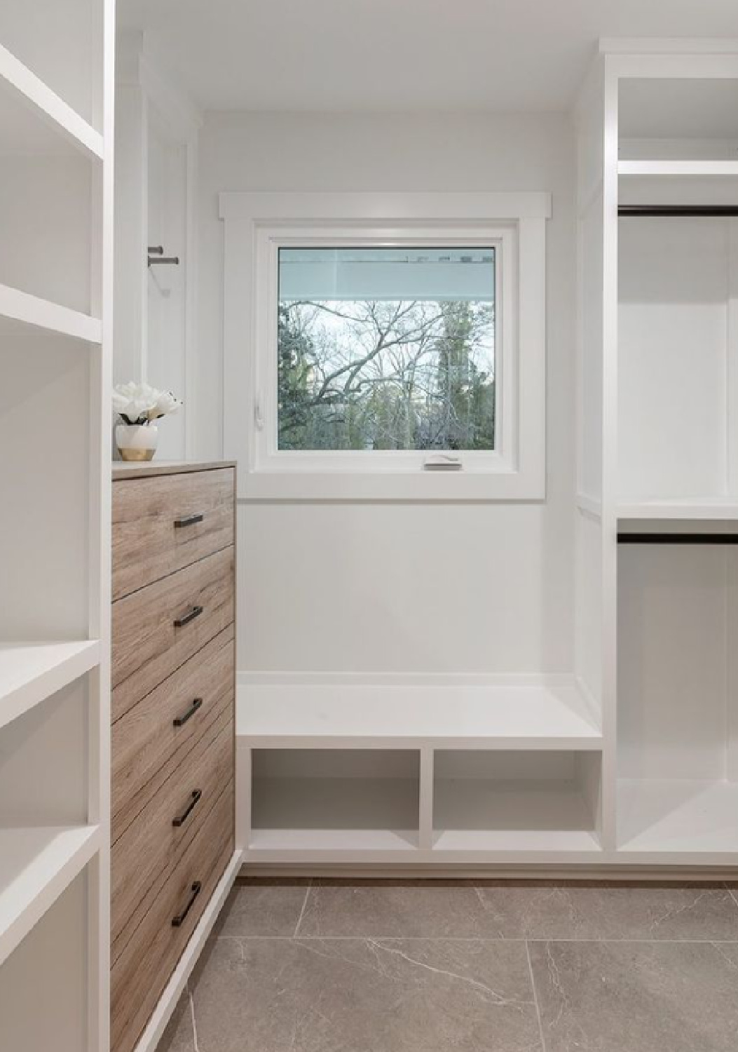 Beautifully designed closet with window and bench beneath it - @kkdesignco. #closetdesign #closetbuiltins #closetgoals