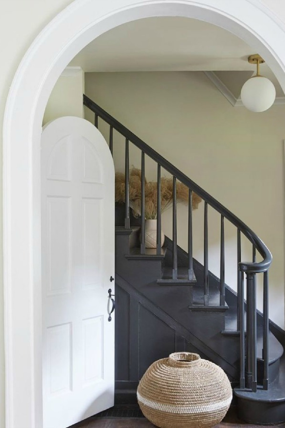 Leanne Ford painted this gorgeous staircase PPG Black Magic, Walls: PPG Sugar Soap; trim: Delicate White; Stairs: Black Magic. #whitepaintcolors #leanneford #restoredbythefords