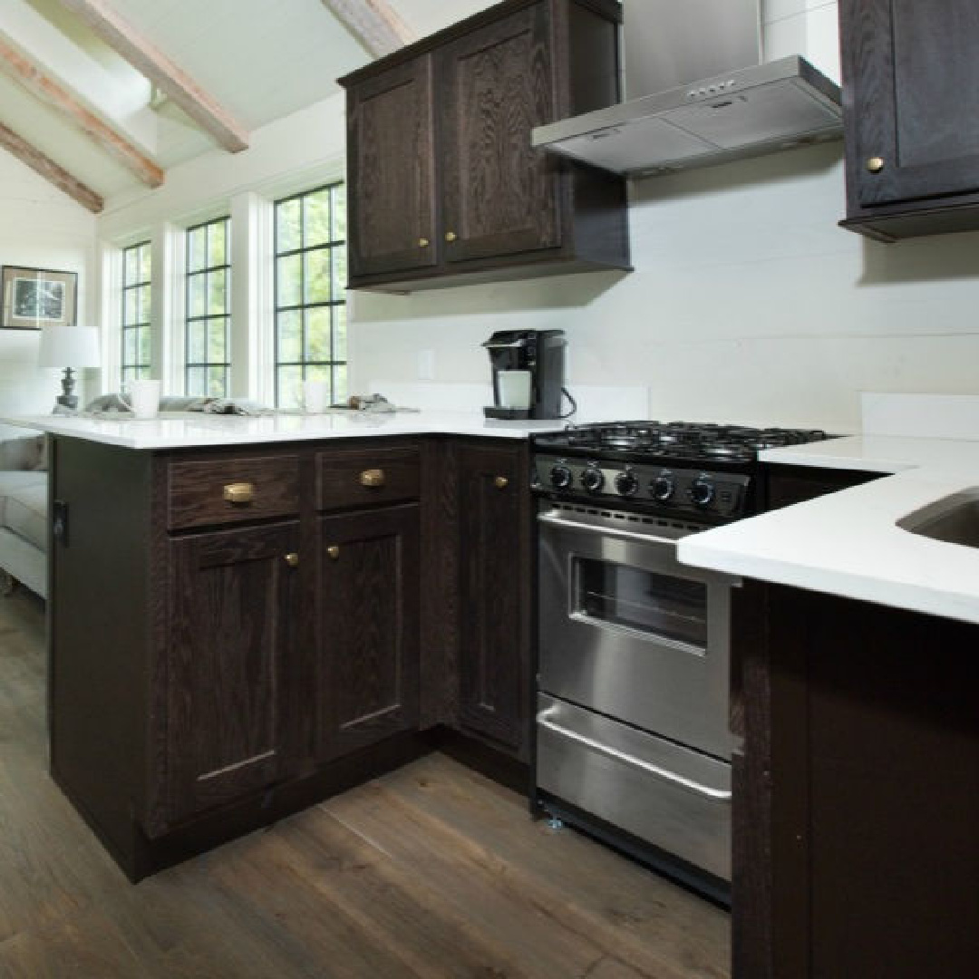 Kitchen with dark cabinets in Jeffrey Dungan designed tiny house with finely crafted Low Country style -one of the cottages at The Retreat at Oakstone in Tennessee. #tinyhousedesign