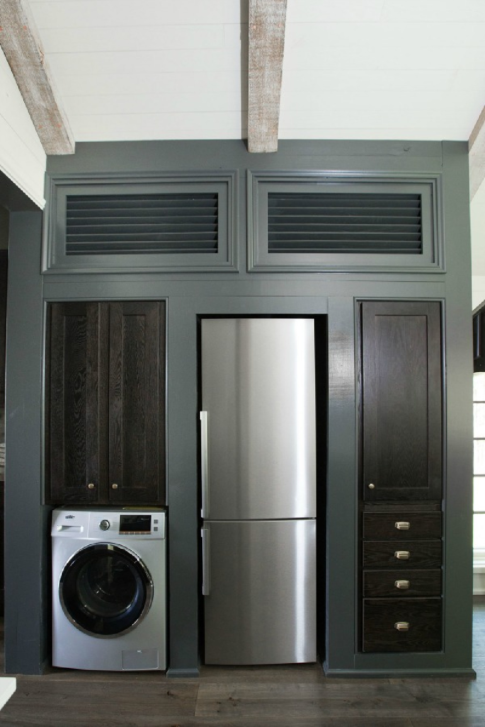 Laundry area with builtins and frig in Jeffrey Dungan designed tiny house with finely crafted Low Country style -one of the cottages at The Retreat at Oakstone in Tennessee. #tinyhousedesign