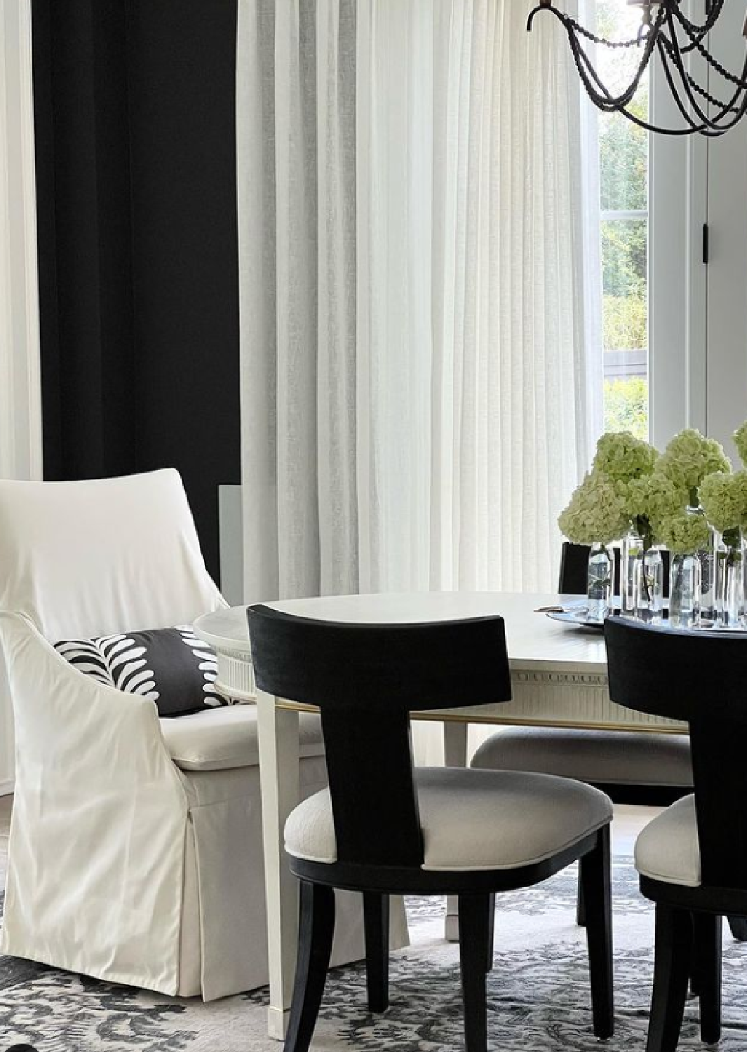 Dramatic deep black painted walls of sophisticated and elegant dining room with design by Sherry Hart. #blackpaintcolors #blackrooms #diningroom #blackandwhiteinteriors