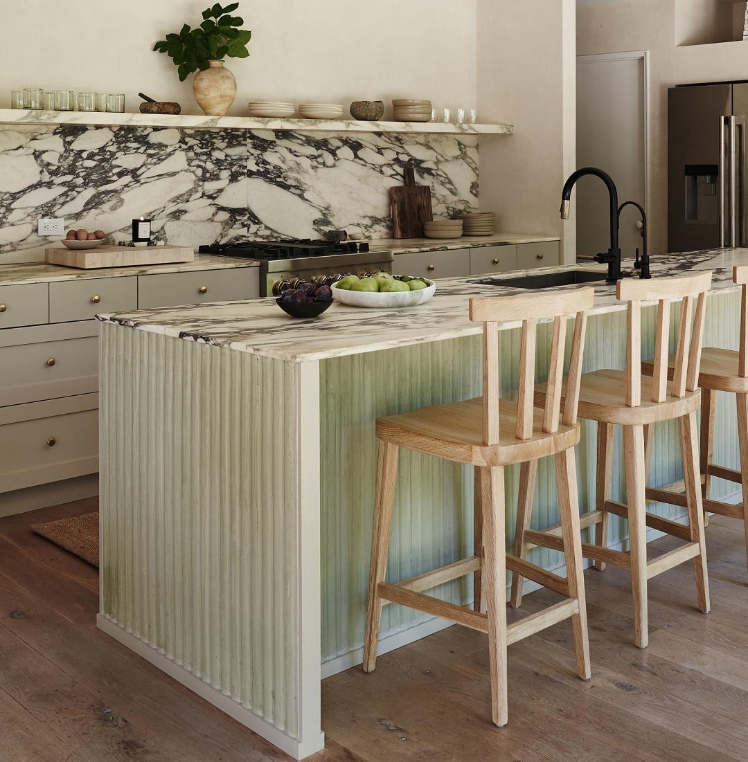 Jenni Kayne minimal modern pale green kitchen with fluted island detail and dramatic marble with dark veining. #jennikaynekitchen #palegreenkitchen #californiamodern