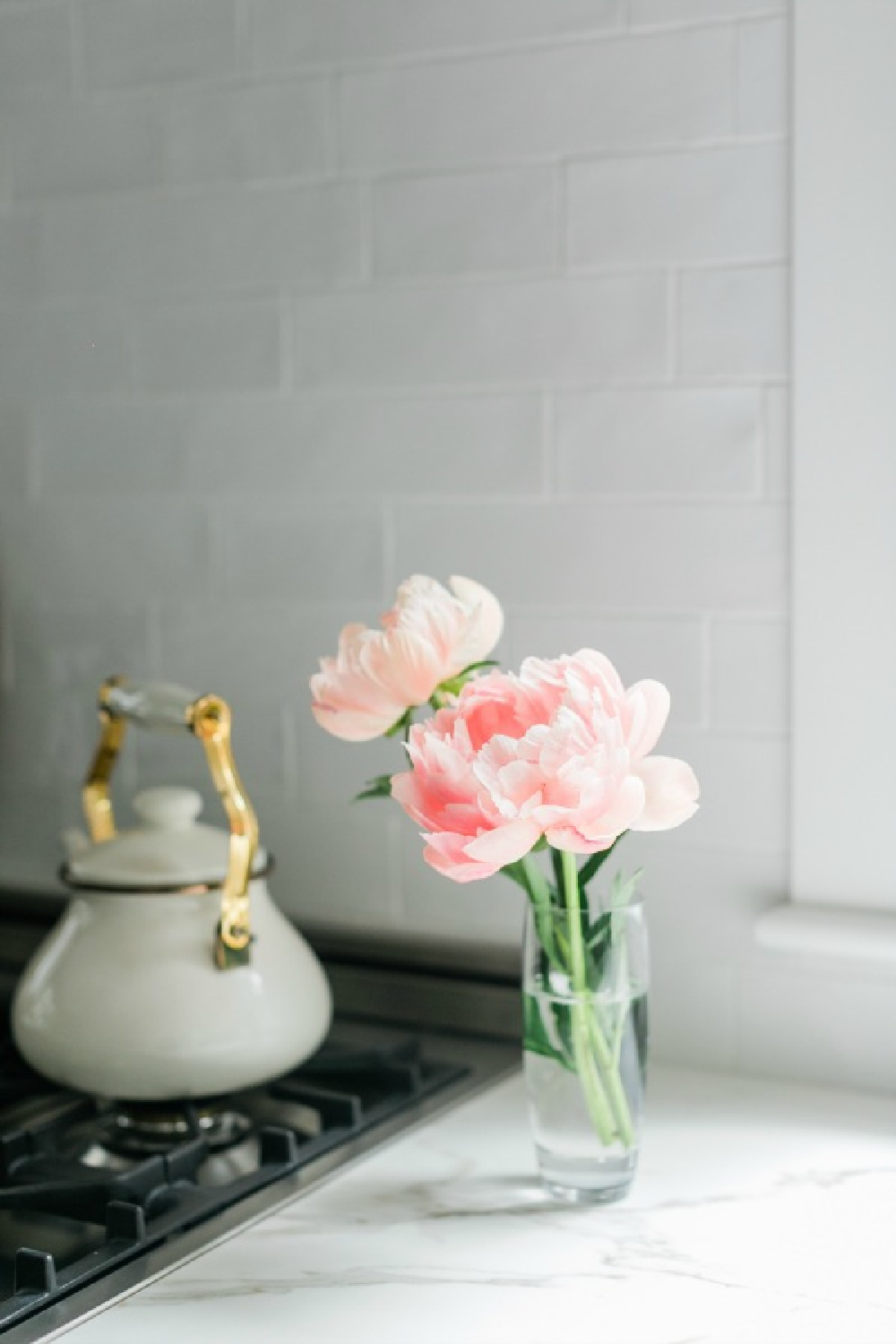 Elegant white farmhouse kitchen with Benjamin Moore Repose Grey cabinets, subway tile, gold accents, and reclaimed barn wood. Design: Finding Lovely. Wall color: Benjamin Moore Chantilly Lace.