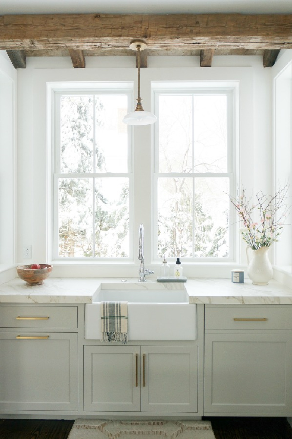 Elegant white farmhouse kitchen with Benjamin Moore Repose Grey cabinets, subway tile, gold accents, and reclaimed barn wood. Design: Finding Lovely. Wall color: Benjamin Moore Chantilly Lace.