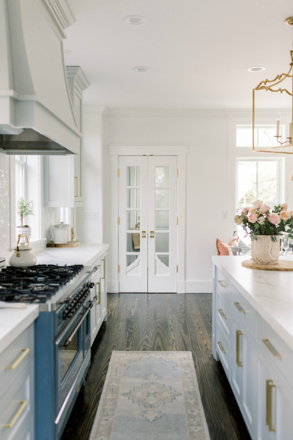 Elegant white farmhouse kitchen with Benjamin Moore Repose Grey cabinets, subway tile, gold accents, and reclaimed barn wood. Design: Finding Lovely. Wall color: Benjamin Moore Chantilly Lace.