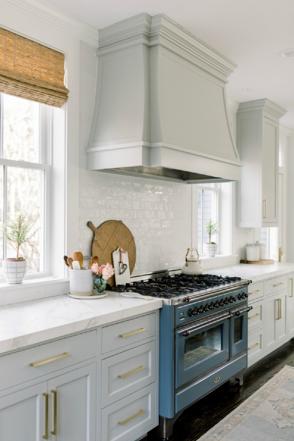 Elegant white farmhouse kitchen with Benjamin Moore Repose Grey cabinets, subway tile, gold accents, and reclaimed barn wood. Design: Finding Lovely. Wall color: Benjamin Moore Chantilly Lace.