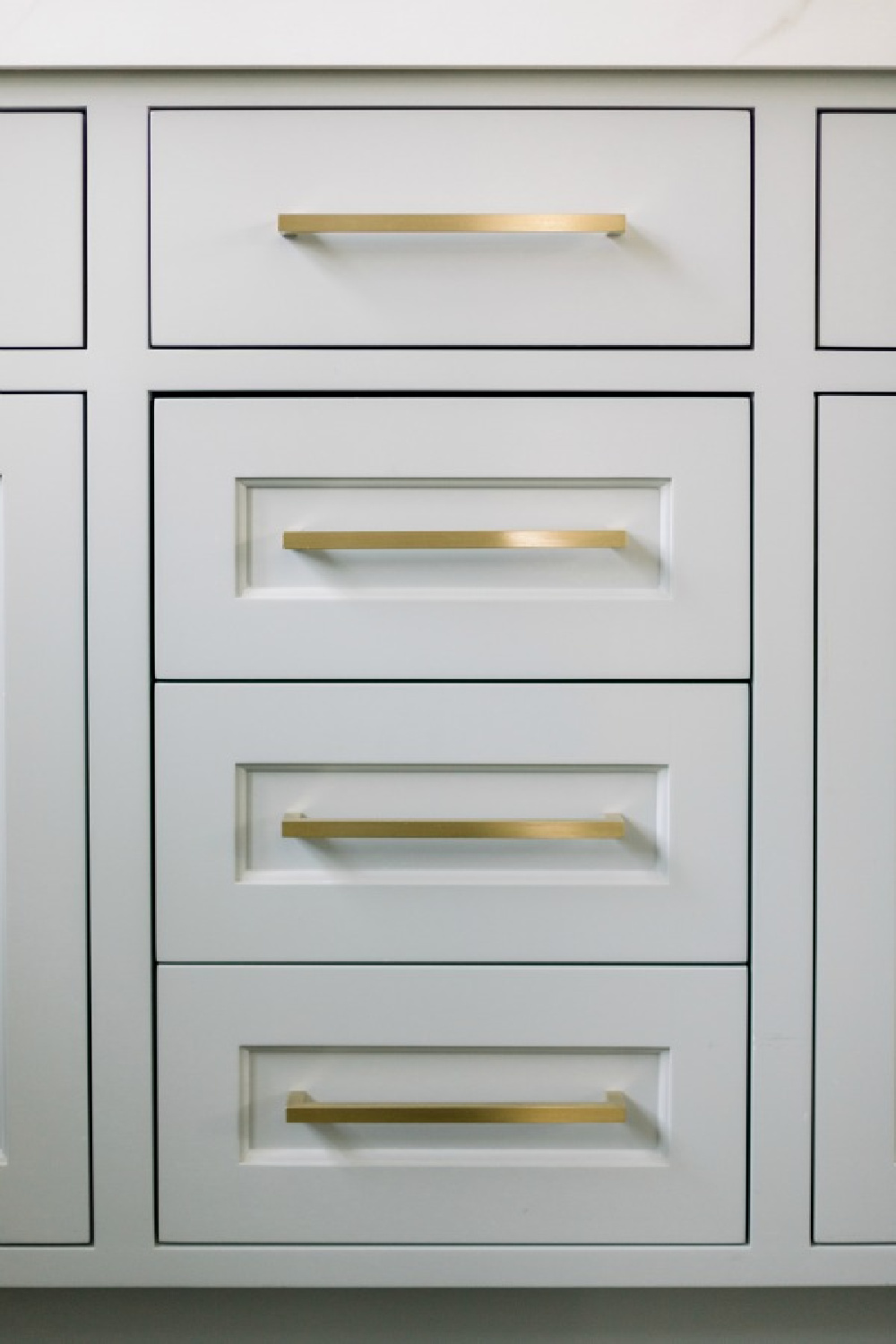 Elegant white farmhouse kitchen with Benjamin Moore Repose Grey cabinets, subway tile, gold accents, and reclaimed barn wood. Design: Finding Lovely. Wall color: Benjamin Moore Chantilly Lace.