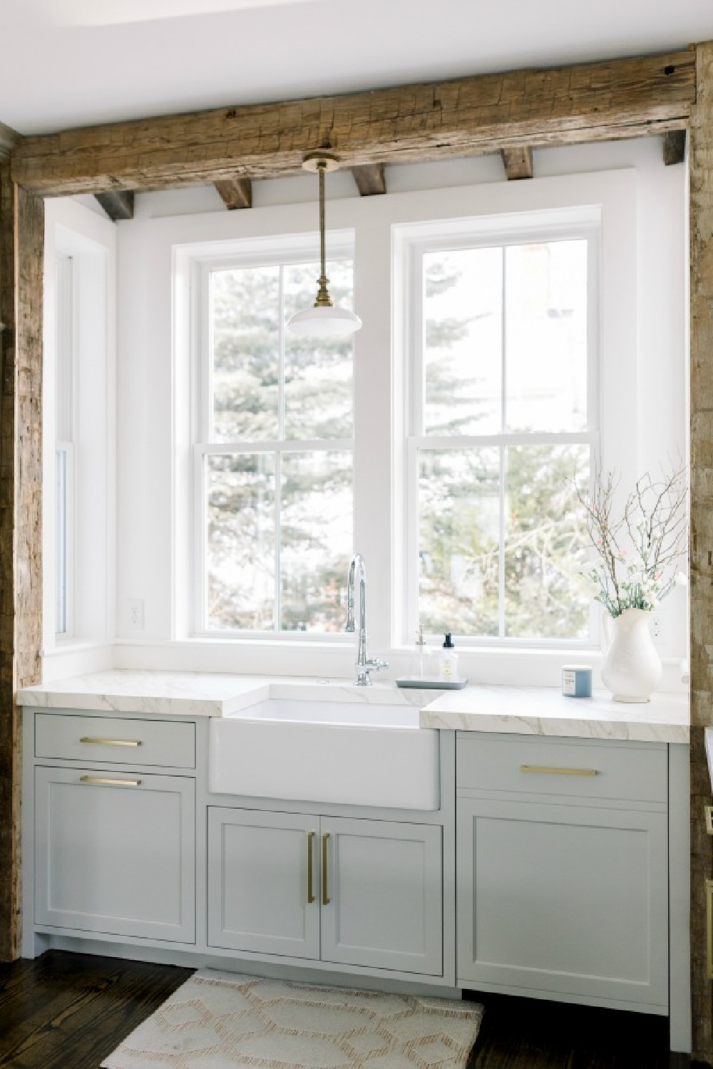 Elegant white farmhouse kitchen with Benjamin Moore Repose Grey cabinets, subway tile, gold accents, and reclaimed barn wood. Design: Finding Lovely. Wall color: Benjamin Moore Chantilly Lace.