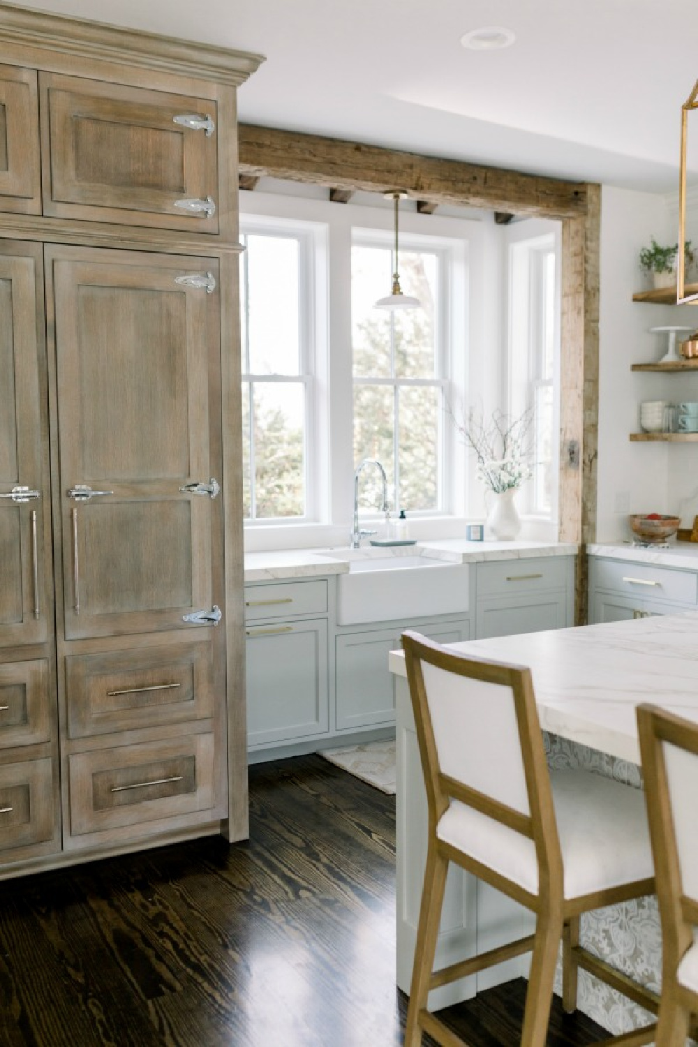 Elegant white farmhouse kitchen with Benjamin Moore Repose Grey cabinets, subway tile, gold accents, and reclaimed barn wood. Design: Finding Lovely. Wall color: Benjamin Moore Chantilly Lace.