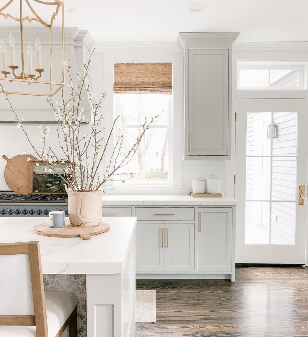 Elegant white farmhouse kitchen with Benjamin Moore Repose Grey cabinets, subway tile, gold accents, and reclaimed barn wood. Design: Finding Lovely. Wall color: Benjamin Moore Chantilly Lace.