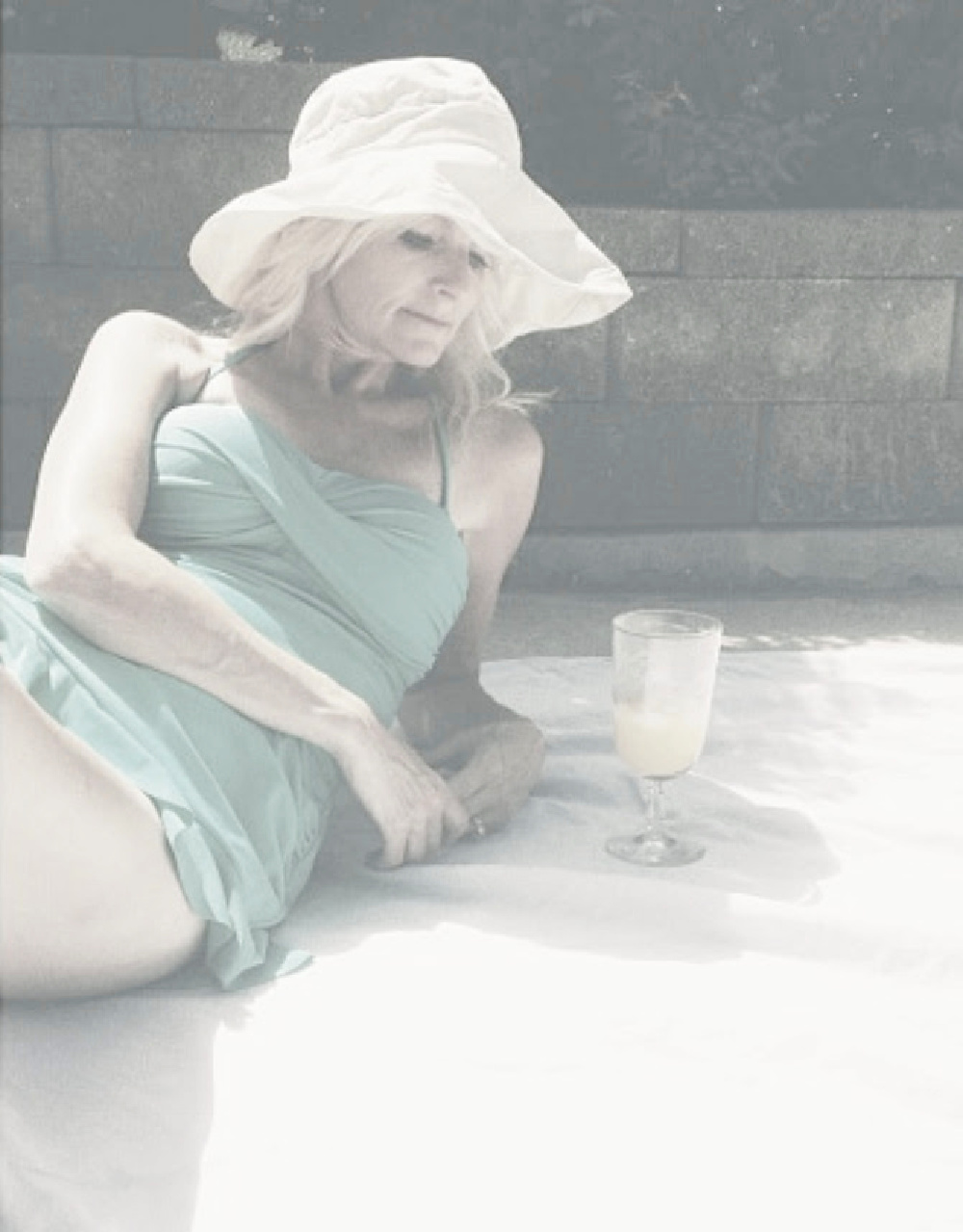 Michele of Hello Lovely in a swimsuit and floppy beach hat. #coastalgrandmother
