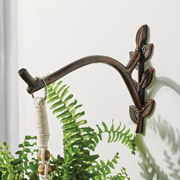 Bronze metal planter hook is wall mounted and resembles a faux branch or twig.