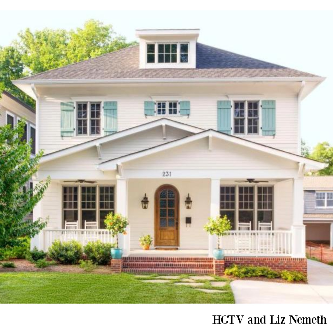 Oyster White (Sherwin-Williams) paint color on a beautiful house with bright blue shutters and arched front door - HGTV (photo Liz Nemeth). #oysterwhite #swoysterwhite #whitehouseexteriors