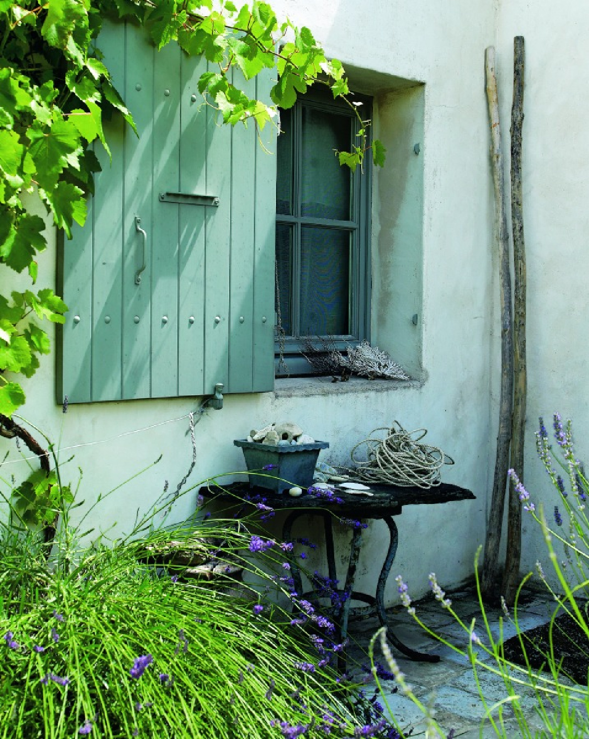 French farmhouse exterior with green shutters, climbing vines, and rustic textures - from LA VIE EST BELLE by Henrietta Heald. #frenchcountryliving #frenchfarmhouseexterior