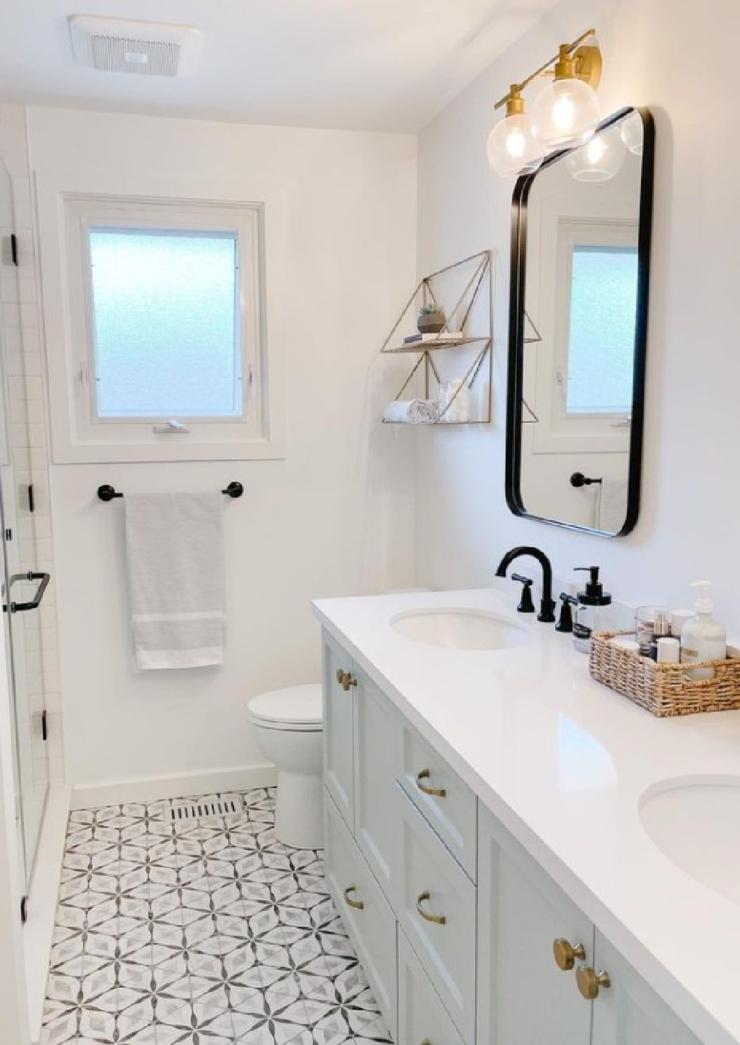 Benjamin Moore Smoke paint color on a lovely light blue bathroom vanity cabinet - Jennifer Beaudry Design. #benjaminmooresmoke #bluepaintcolors #calmpaintcolors