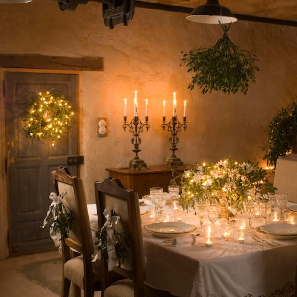French Christmas dining table with candlelight, rustic stone walls, and traditional furniture - Le Moulin Bregeon. #frenchchristmas #frenchcountrydiningroom #holidaytables