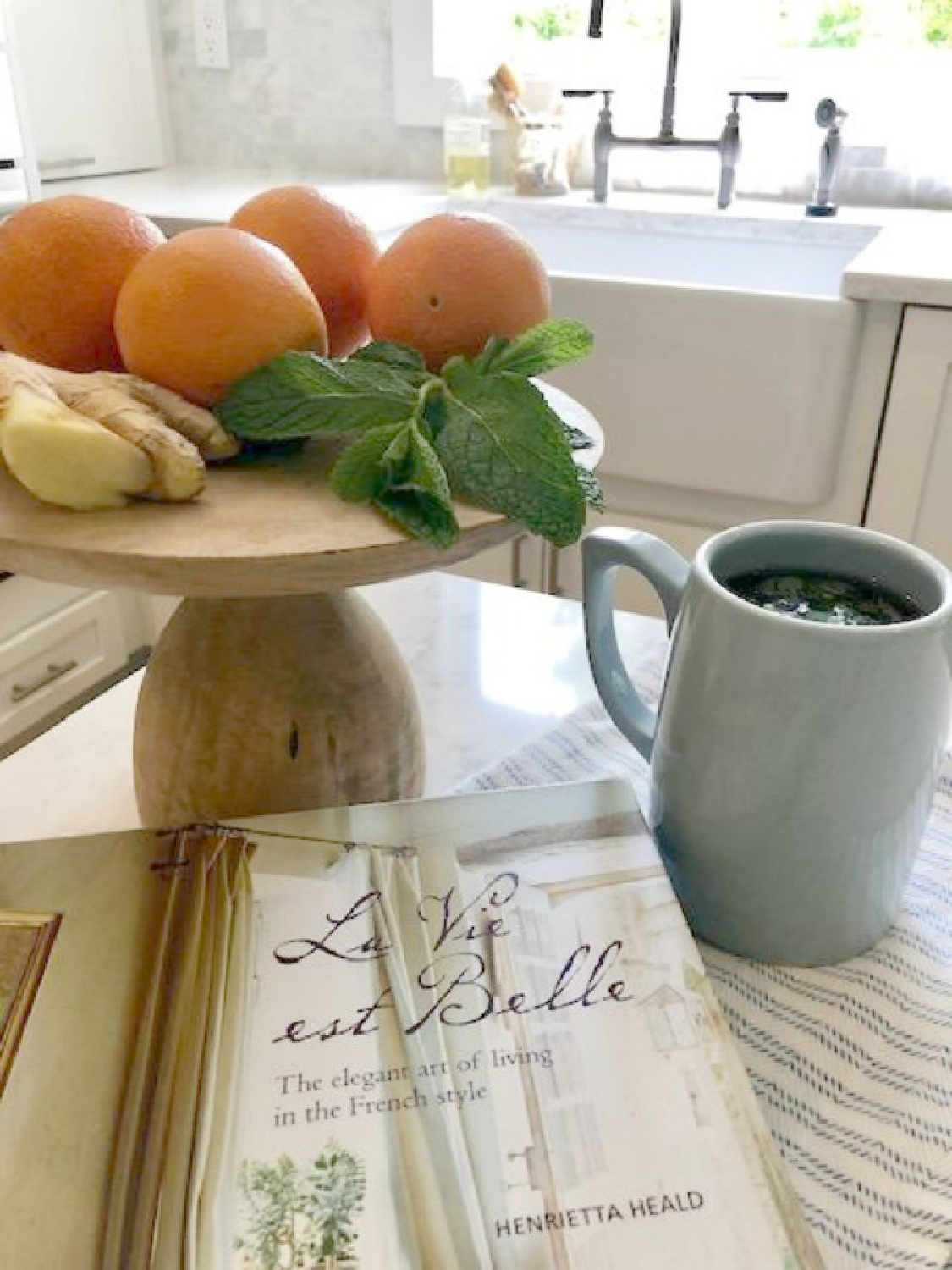 Hello Lovely Studio's white Shaker kitchen with ingredients for mint ginger tea on the counter. #frenchkitchen #frenchfarmhousekitchen